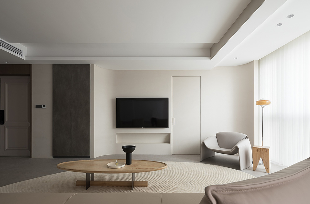 白禾設計 - 現代奶油風寧靜客廳，柔和色調結合無縫弧形牆面、隱藏門、極簡木質茶几與透光落地窗紗簾。