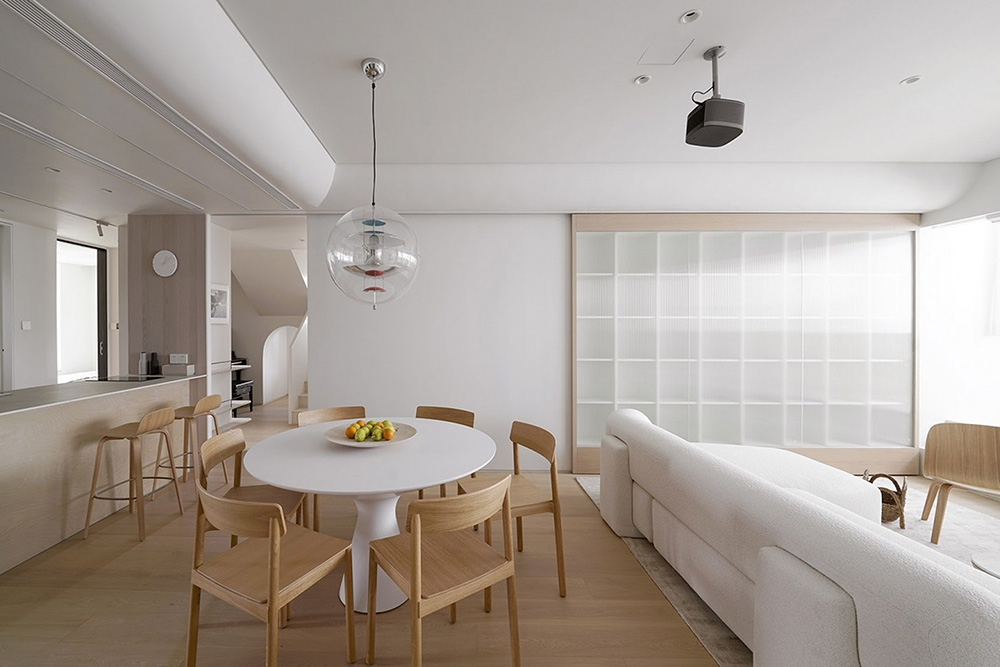 白禾設計 - 日式北歐風開放式餐廳，具備明亮溫潤的木質調，結合玻璃拉門、木質圓桌椅與隱藏式投影機。